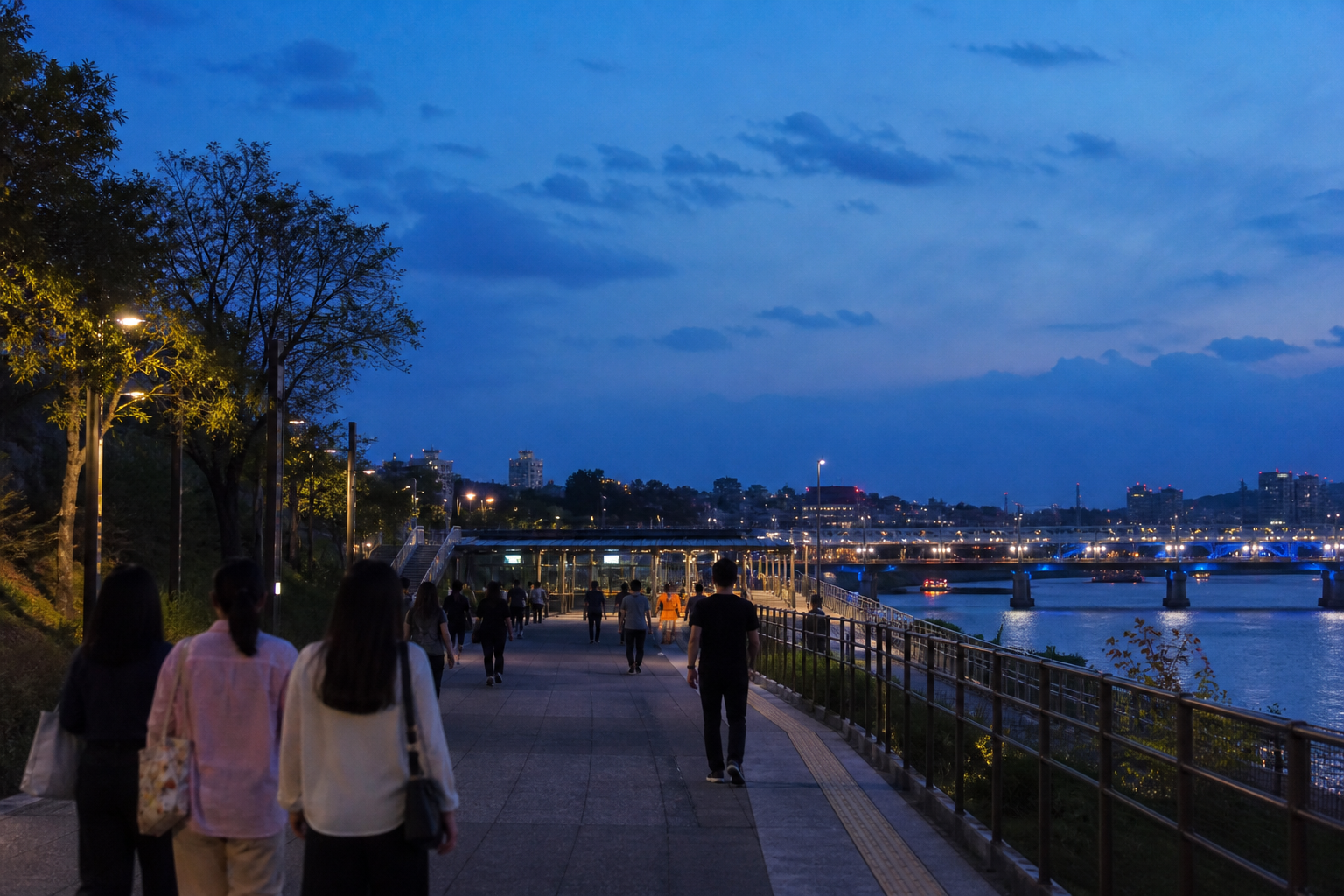 Visitors leaving along the Han River path on Nodeul Island after a Seoul concert at night
