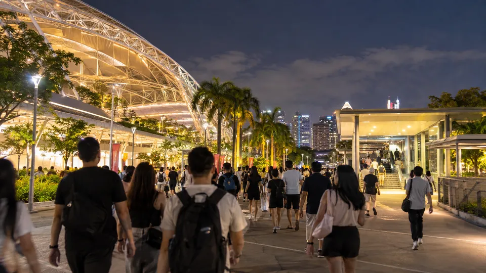 Concertgoers walking away from Singapore National Stadium at night