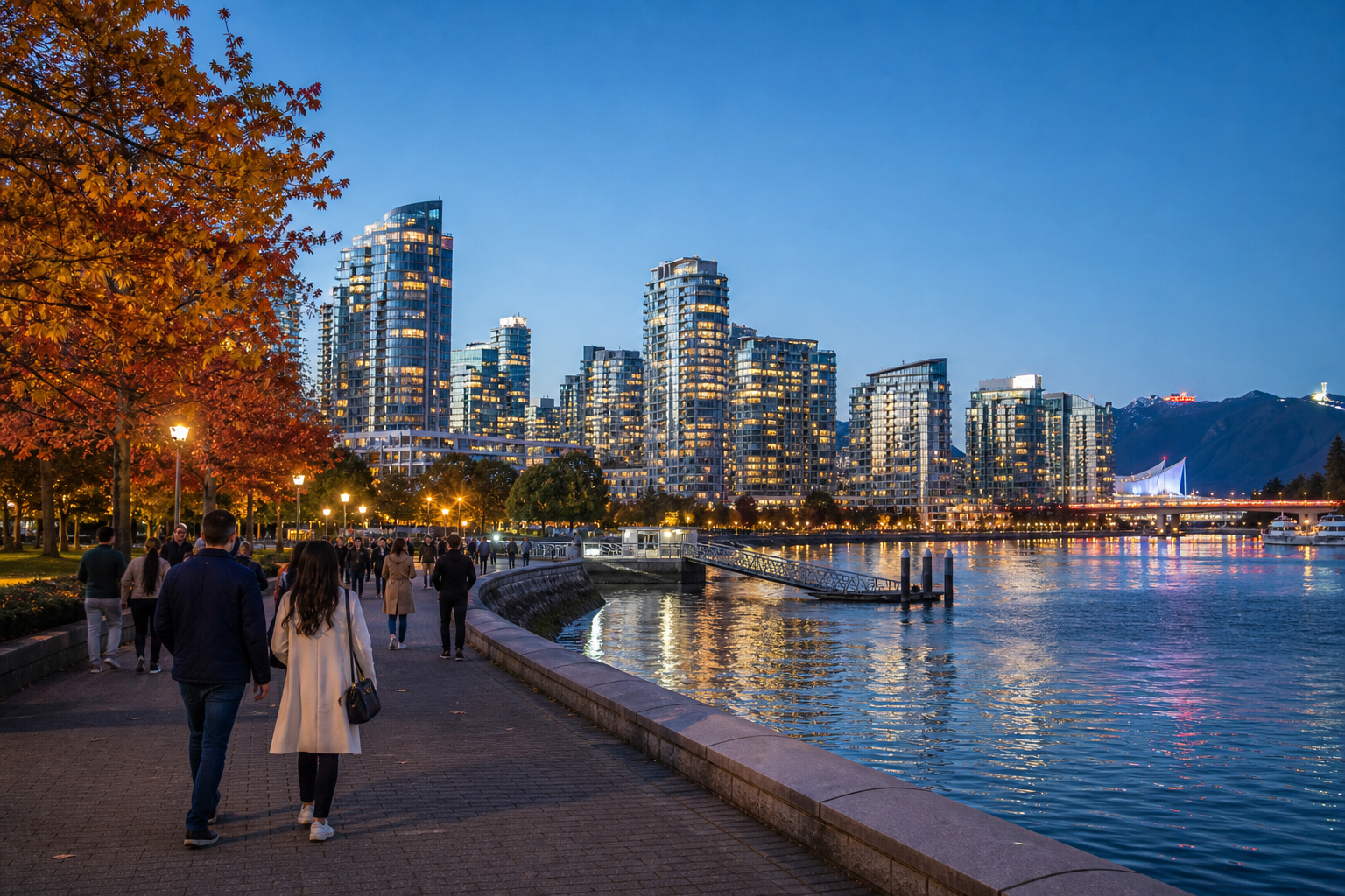 秋の夕方、バンクーバーのFalse Creek水辺と市街地を歩く旅行者