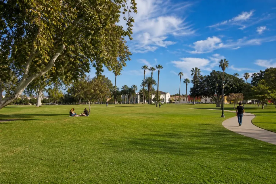 Broad lawn, palms and walking paths at Edward Vincent Jr. Park in Inglewood